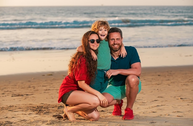 Foto família feliz pai mãe e filho criança de mãos dadas e caminhar ao longo do mar surfar na praia de areia pais ativos e pessoas atividade ao ar livre em férias de verão tropicais com crianças