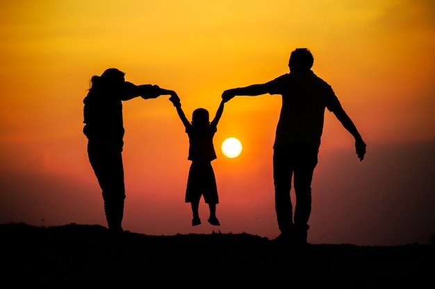 Família feliz, pai, mãe, filho na natureza, pôr do sol