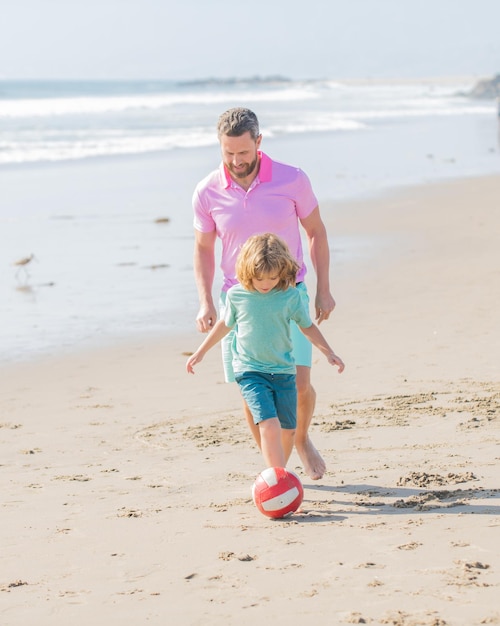 Familia feliz de papá hombre y niño niño jugando a la pelota en la relación de playa