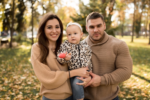 Familia feliz en el parque de otoño riendo