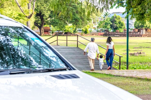 Familia feliz en el parque Padre, madre e hijo contra el parque. Concepto de familia.