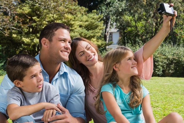 Familia feliz en un parque tomando fotos