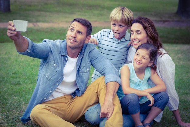 Familia feliz en el parque tomando selfie