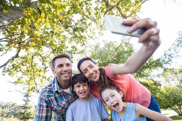 Familia feliz en el parque tomando selfie