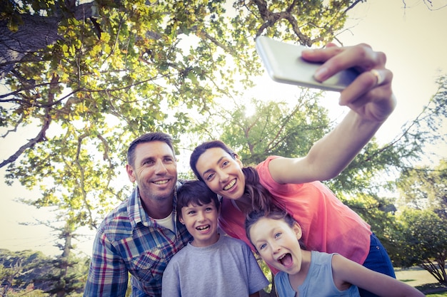 Familia feliz en el parque tomando selfie