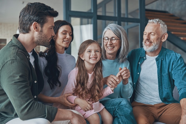 Familia feliz pasar tiempo juntos y sonriendo mientras está sentado en el sofá en casa