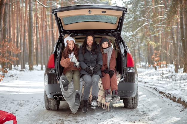 Familia feliz en un paseo al aire libre en el bosque soleado de invierno