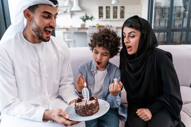 Família feliz, passando algum tempo juntos. Pais árabes e criança comemorando aniversário juntos