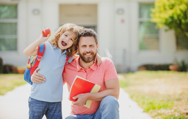 Familia feliz en el patio de la escuela niño de la escuela que va a la escuela con el padre