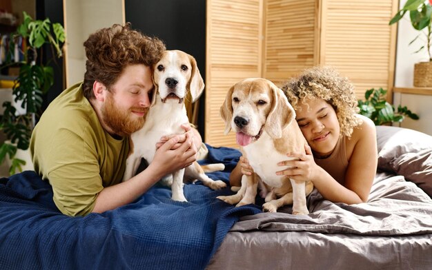 Familia feliz con perros en el dormitorio