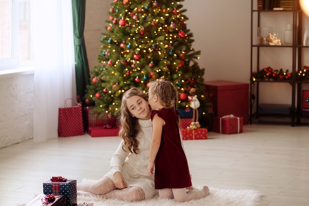 Família feliz perto da árvore de Natal em casa com presentes