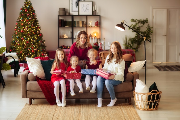 Família feliz perto da árvore de natal em casa com presentes