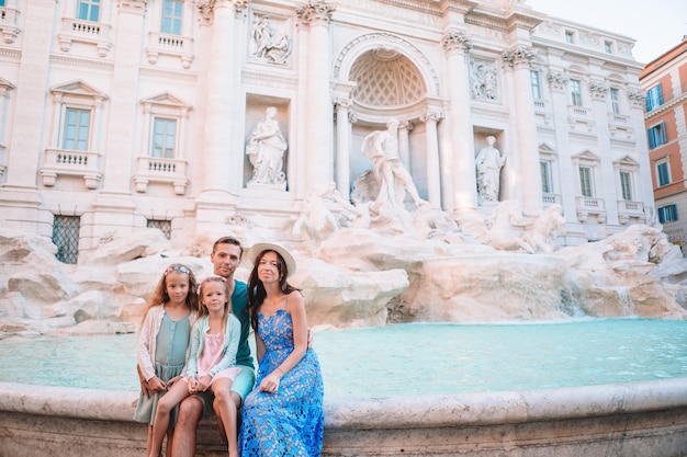 Família feliz perto de fontana di trevi com mapa da cidade