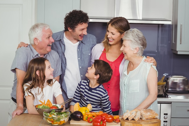 Familia feliz de pie en la cocina