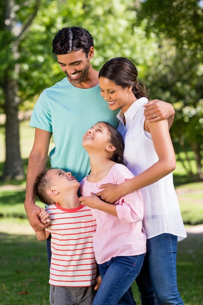 Familia feliz de pie en el parque