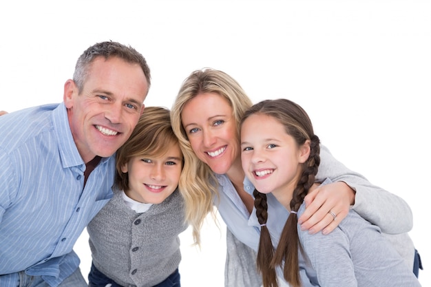 Familia feliz de pie y sonriendo a la cámara