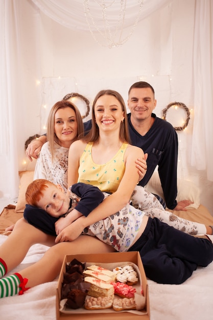 Familia feliz en pijama en la cama