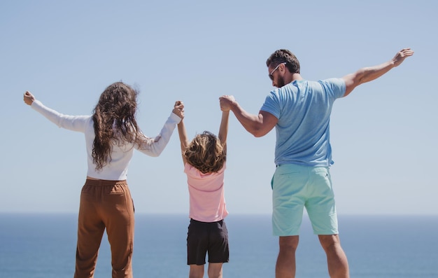 Familia feliz en la playa gente divirtiéndose en vacaciones de verano padre madre e hijo en el mar azul c