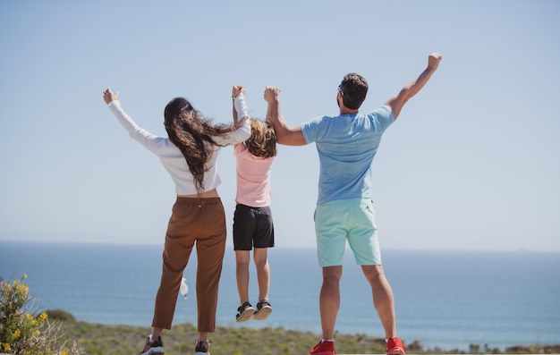 Familia feliz en la playa gente divirtiéndose en vacaciones de verano padre madre e hijo en el mar azul c