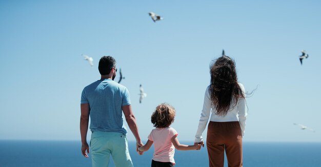 Familia feliz en la playa gente divirtiéndose en vacaciones de verano padre madre e hijo en el mar azul c