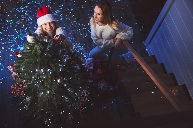 Familia feliz podando el árbol de Año Nuevo juntos