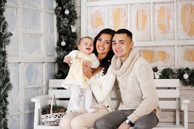 Familia feliz en el porche con adornos navideños