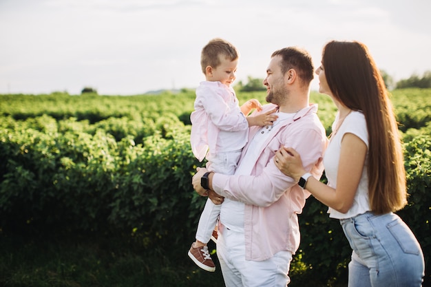 Familia feliz posando en un campo verde