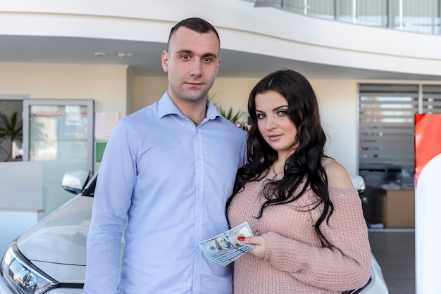 Família feliz posando com carro no showroom