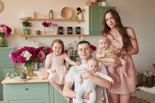 Família feliz posando na cozinha