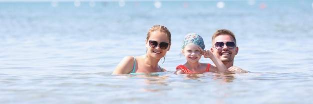 Família feliz posando para uma foto juntos no mar ou oceano