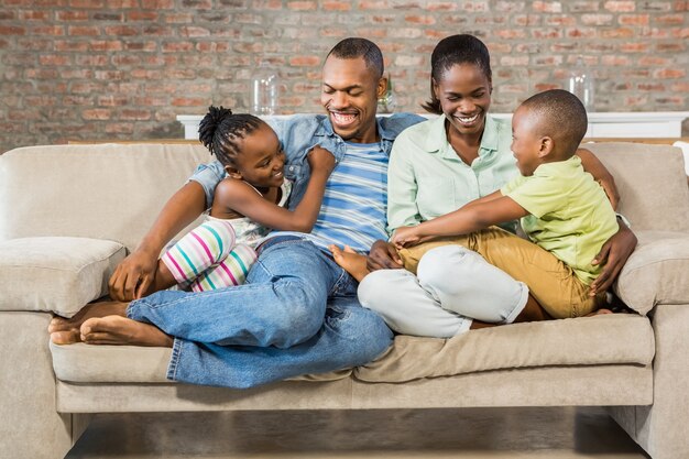 Familia feliz posando en el sofá junto