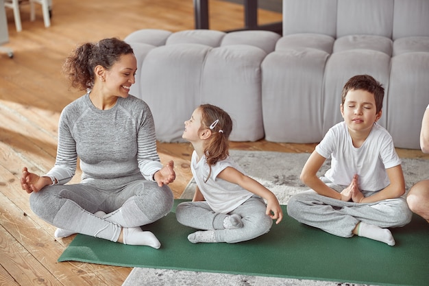 Familia feliz practicando yoga juntos en casa