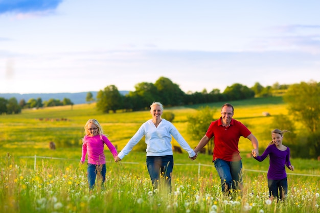 Familia feliz en pradera al atardecer