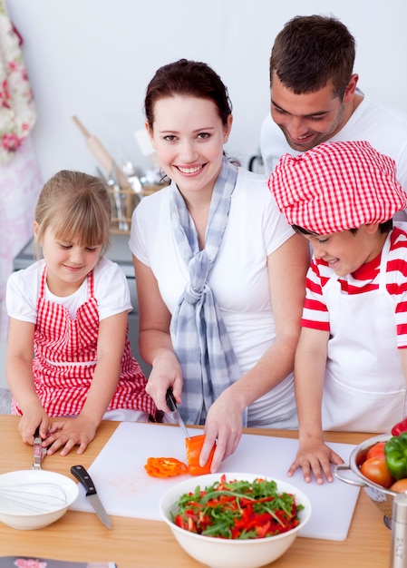 Familia feliz preparando una ensalada en la cocina