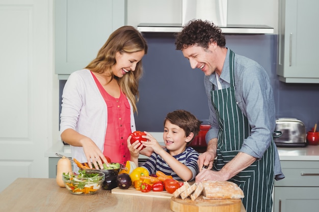 Familia feliz preparando una ensalada de verduras