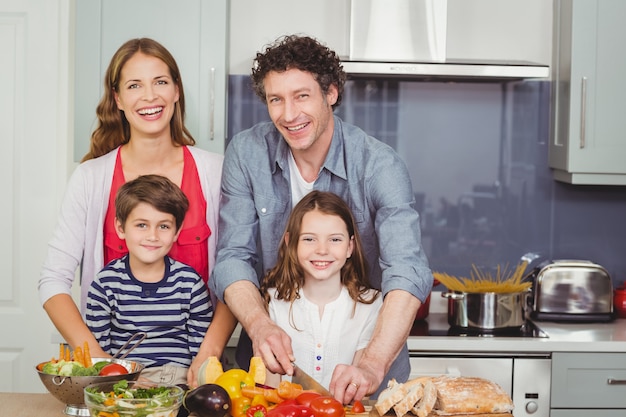 Familia feliz preparando una ensalada de verduras