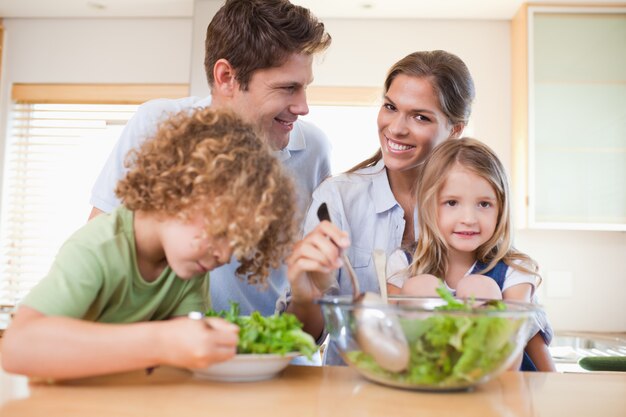 Foto familia feliz preparando una ensalada