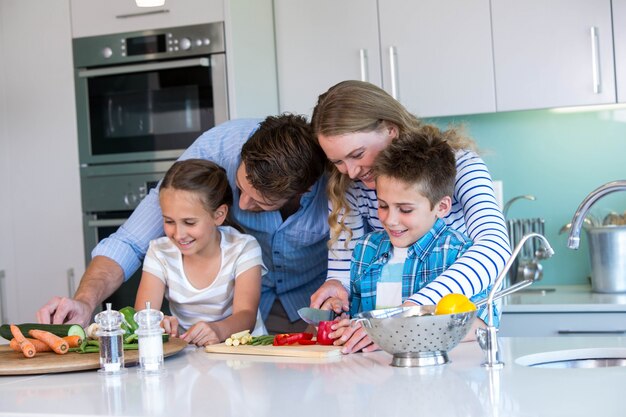 Familia feliz preparando verduras juntos