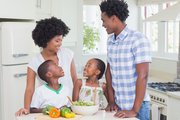 Familia feliz preparando verduras juntos