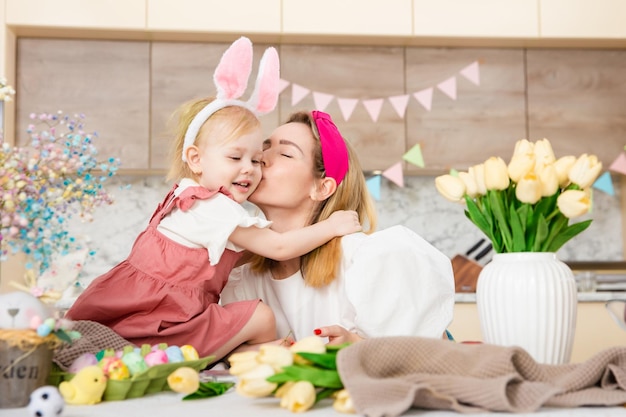 Familia feliz preparándose para Pascua Linda chica abrazando a la madre Actividad en el hogar Concepto de unidad y amor Mamá e hija