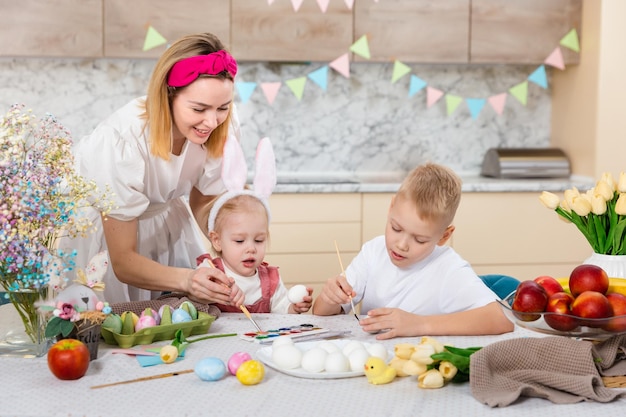 Familia feliz preparándose para Pascua Niño lindo pintando huevos Actividad en el hogar Concepto de unidad y amor Hermano y hermana