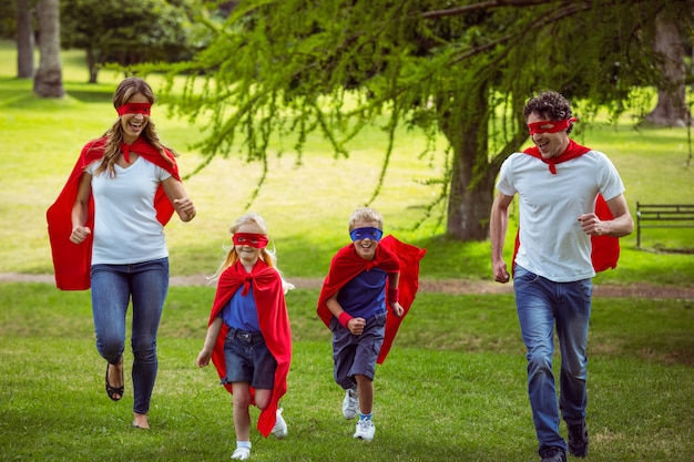 Familia feliz pretendiendo ser superhéroe corriendo