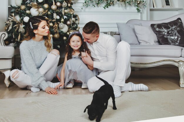 Familia feliz con regalos de Navidad en el piso en casa en Feliz Navidad y Feliz Año Nuevo