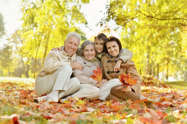 Familia feliz relajándose en el bosque de otoño