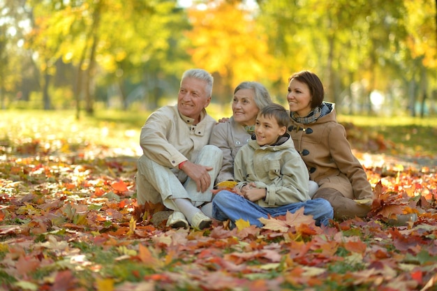 Familia feliz relajándose en el bosque de otoño