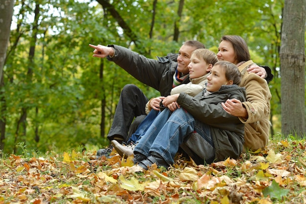 Familia feliz relajándose en el parque de otoño