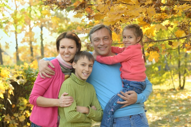 Família feliz relaxando no parque de outono