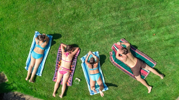 Família feliz relaxante na piscina, vista aérea drone de cima dos pais e filhos se divertir nas férias