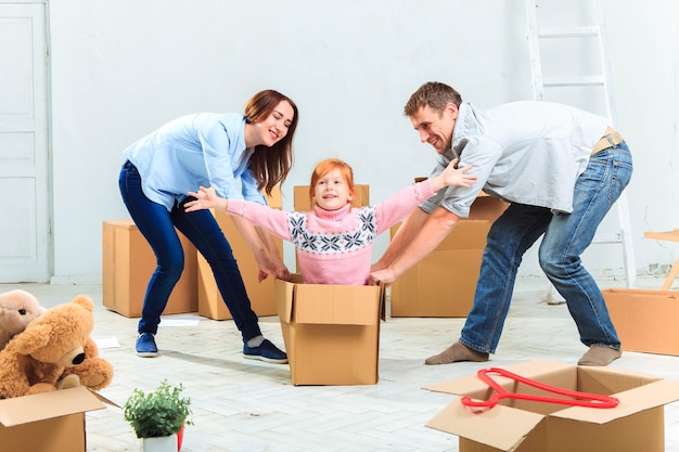 La familia feliz en reparación y reubicación sobre un fondo de cajas