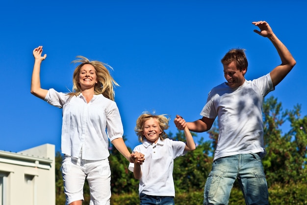 Familia feliz saltando sobre un fondo azul